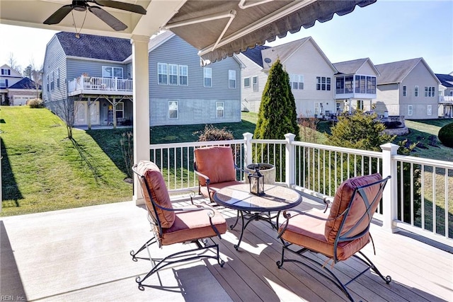 wooden deck featuring ceiling fan and a yard