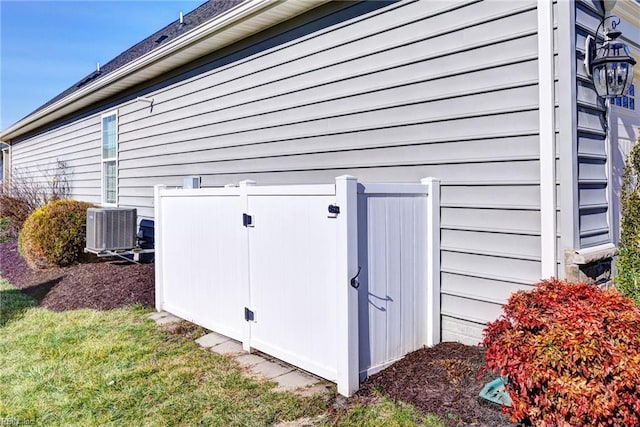 view of property exterior with a storage shed, a lawn, and central air condition unit