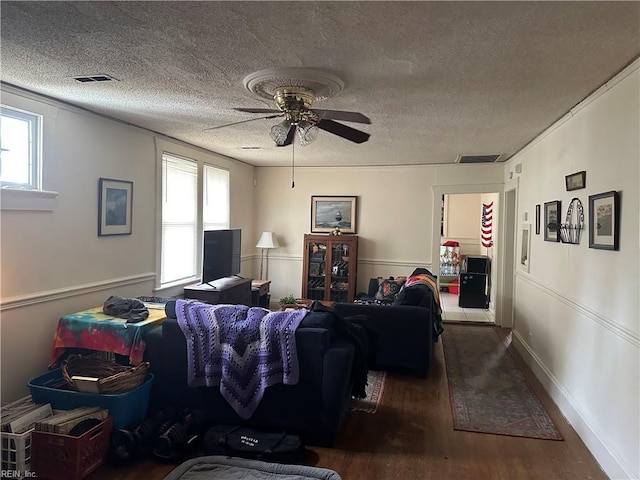 living room featuring wood-type flooring, ceiling fan, and a textured ceiling