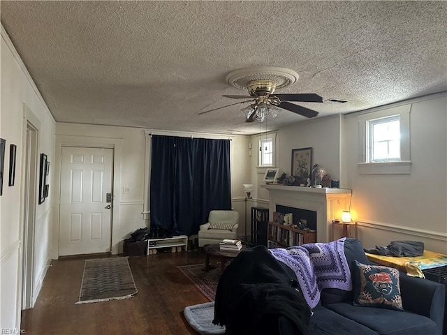 living room featuring ceiling fan, hardwood / wood-style flooring, and a textured ceiling