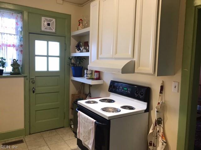 kitchen featuring range with electric cooktop, plenty of natural light, light tile patterned flooring, and white cabinets