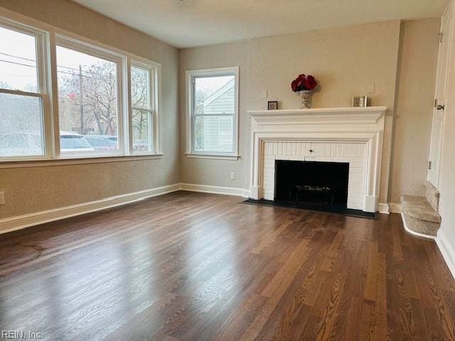 unfurnished living room featuring dark hardwood / wood-style flooring and a fireplace