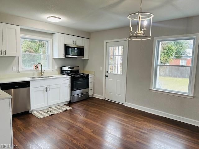 kitchen with white cabinetry, pendant lighting, dark hardwood / wood-style flooring, and stainless steel appliances