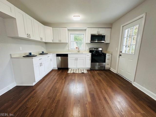 kitchen with white cabinetry, sink, dark wood-type flooring, and stainless steel appliances