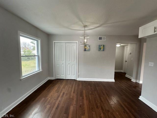 unfurnished dining area with dark hardwood / wood-style flooring and a textured ceiling