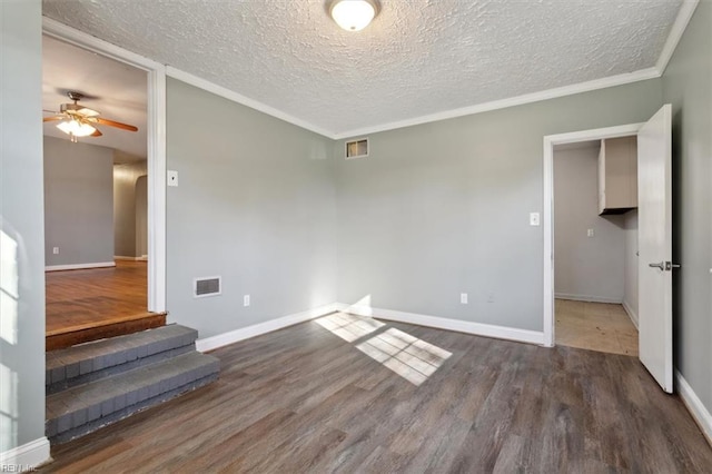 unfurnished room featuring dark hardwood / wood-style flooring, ceiling fan, ornamental molding, and a textured ceiling