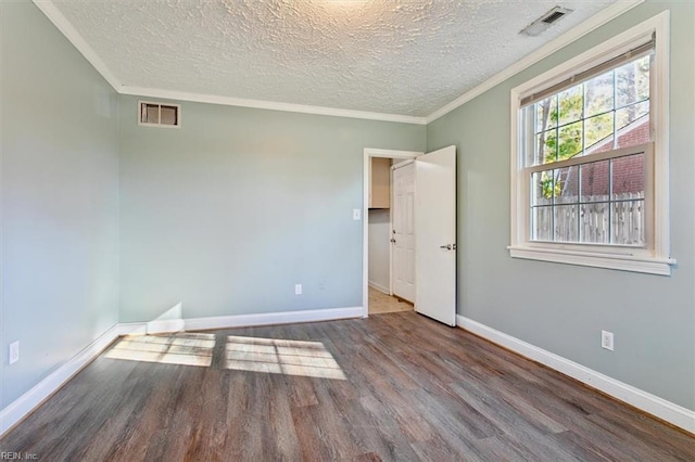 unfurnished room with hardwood / wood-style flooring, ornamental molding, and a textured ceiling