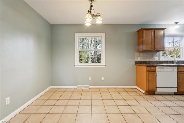 kitchen featuring decorative light fixtures, light tile patterned floors, white dishwasher, a notable chandelier, and decorative backsplash