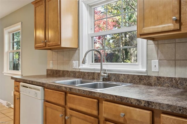 kitchen with dishwasher, sink, and decorative backsplash