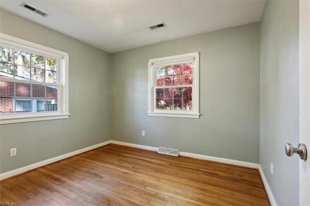 empty room with light hardwood / wood-style floors and a wealth of natural light