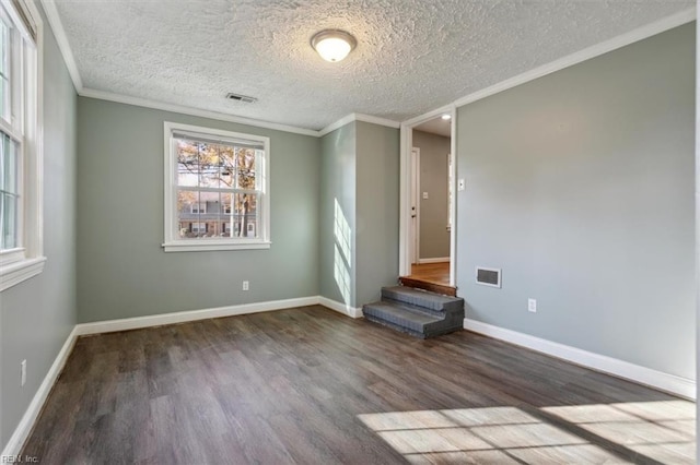 spare room featuring hardwood / wood-style flooring, crown molding, and a textured ceiling