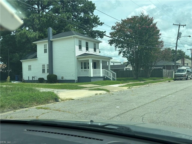 view of side of property with a lawn and a porch