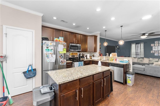 kitchen featuring stainless steel appliances, hanging light fixtures, dark hardwood / wood-style floors, and kitchen peninsula