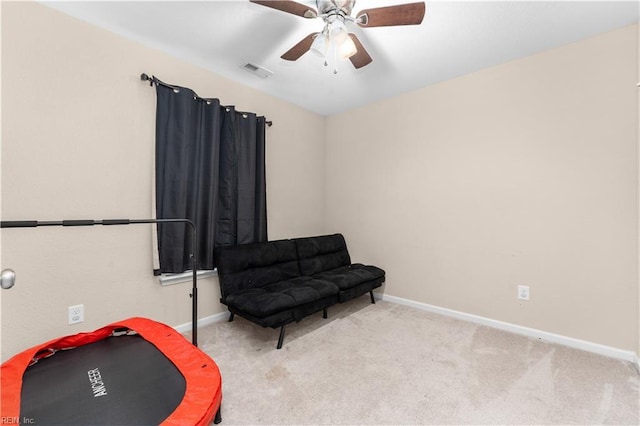 living area featuring light carpet and ceiling fan