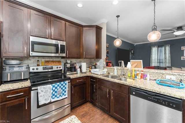 kitchen featuring sink, stainless steel appliances, ornamental molding, decorative light fixtures, and kitchen peninsula