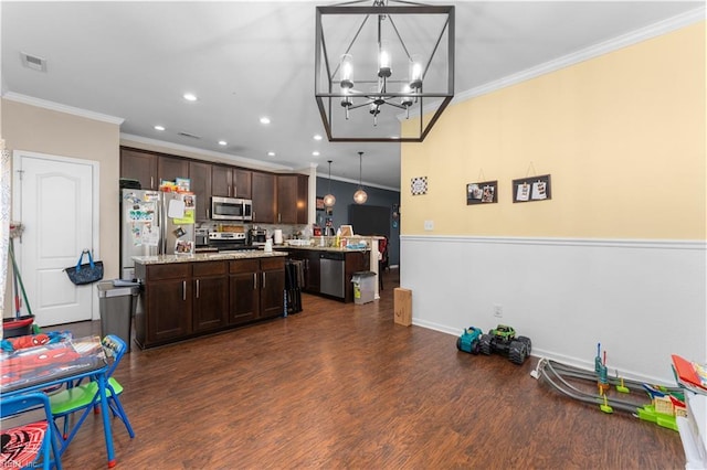 kitchen with appliances with stainless steel finishes, decorative light fixtures, a center island, and dark brown cabinets