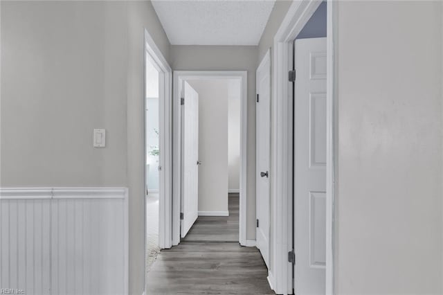 hallway featuring hardwood / wood-style flooring and a textured ceiling