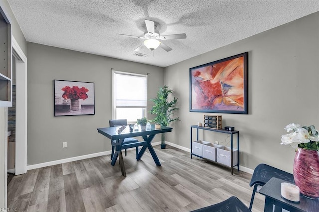 office area featuring a textured ceiling, light hardwood / wood-style floors, and ceiling fan