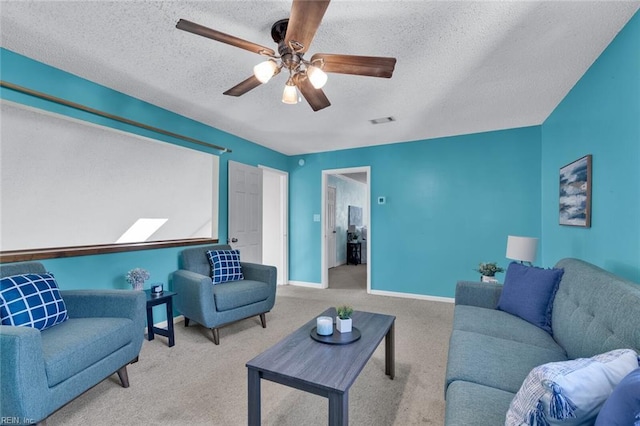 carpeted living room featuring ceiling fan, a skylight, and a textured ceiling