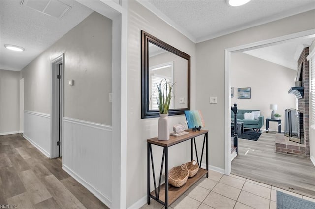 hallway featuring light tile patterned floors and a textured ceiling