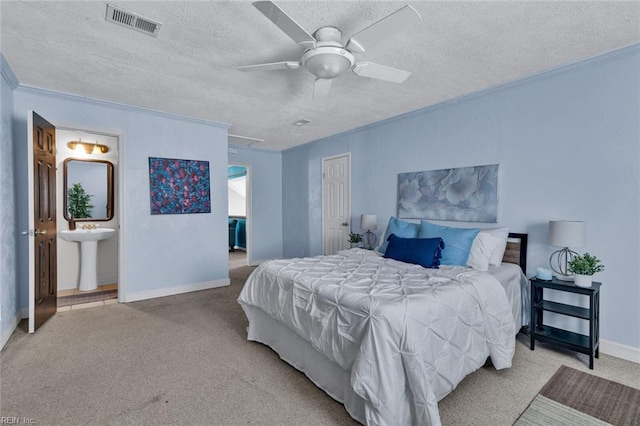 bedroom featuring sink, connected bathroom, a textured ceiling, light carpet, and a closet