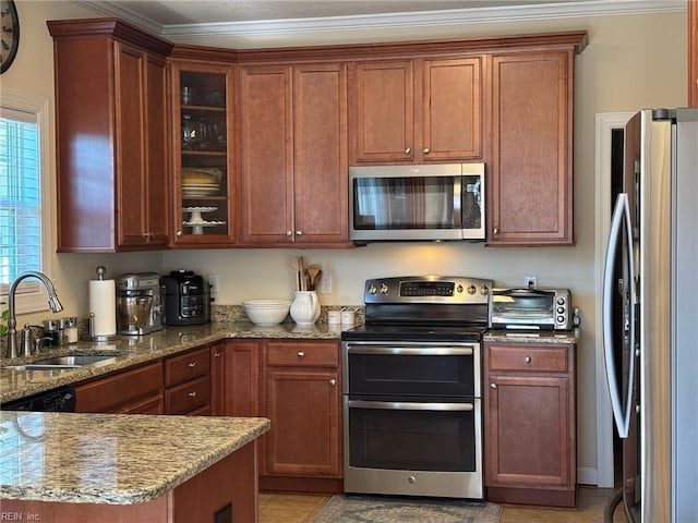 kitchen featuring stone countertops, sink, and appliances with stainless steel finishes