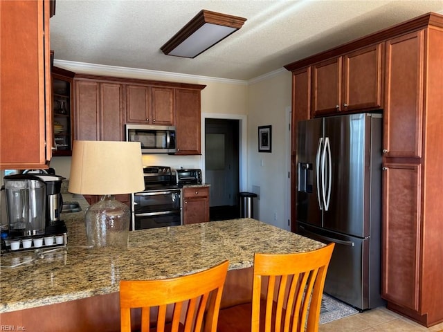 kitchen with a breakfast bar, stainless steel appliances, light stone countertops, ornamental molding, and kitchen peninsula