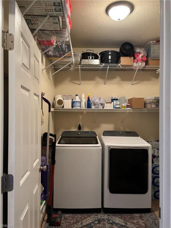 washroom with washing machine and clothes dryer and a textured ceiling