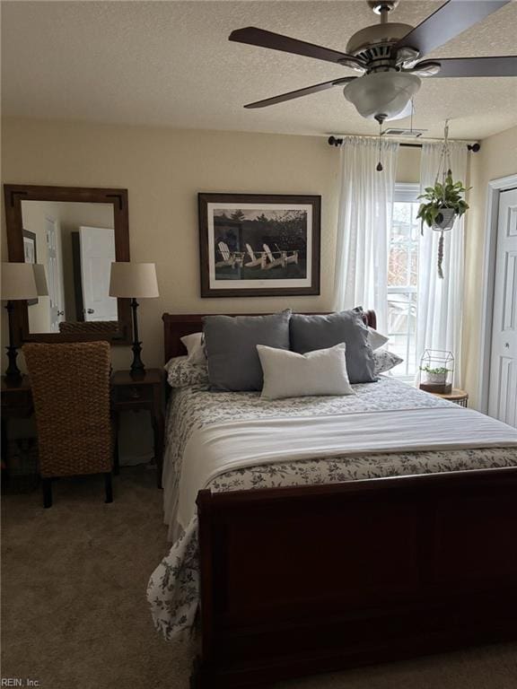 carpeted bedroom with ceiling fan and a textured ceiling