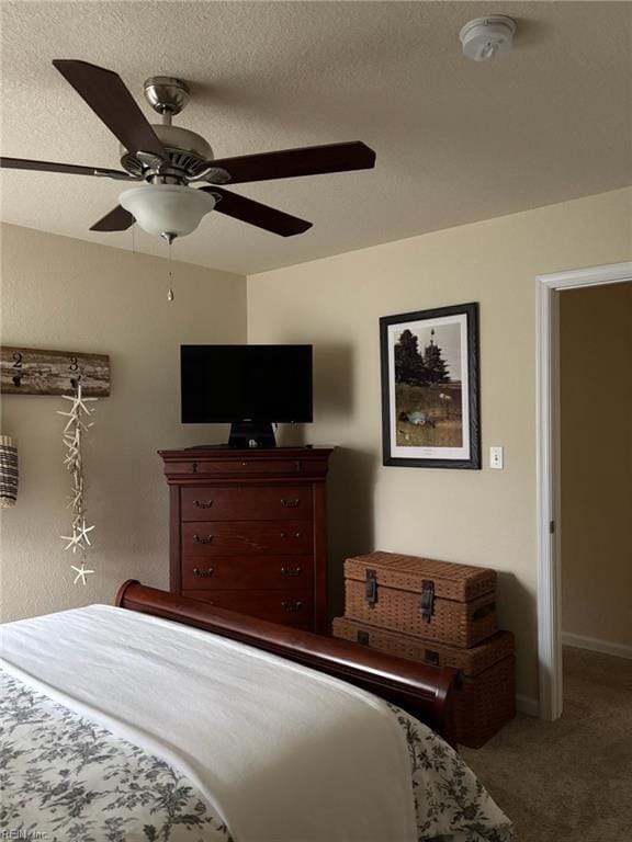 bedroom with ceiling fan, carpet, and a textured ceiling