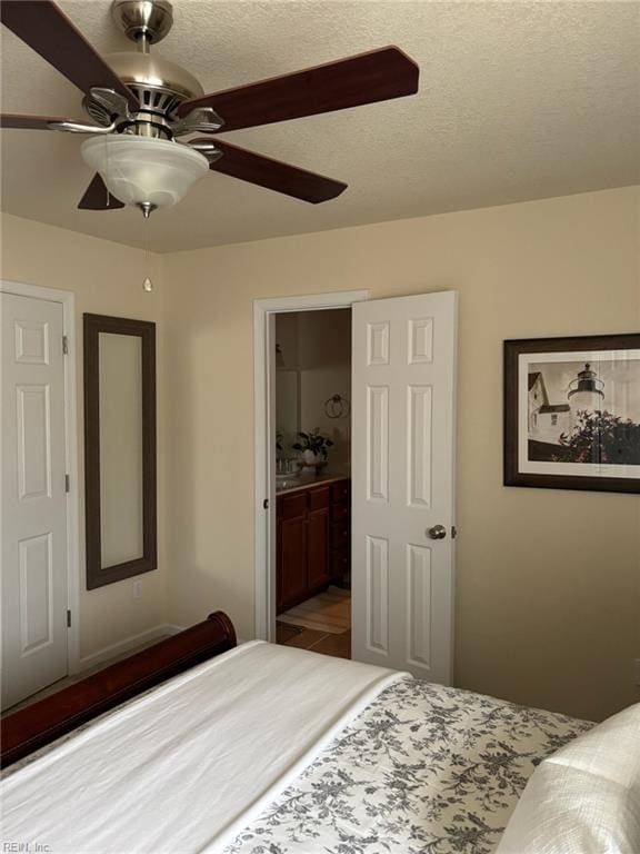 bedroom with ceiling fan, a textured ceiling, and ensuite bathroom