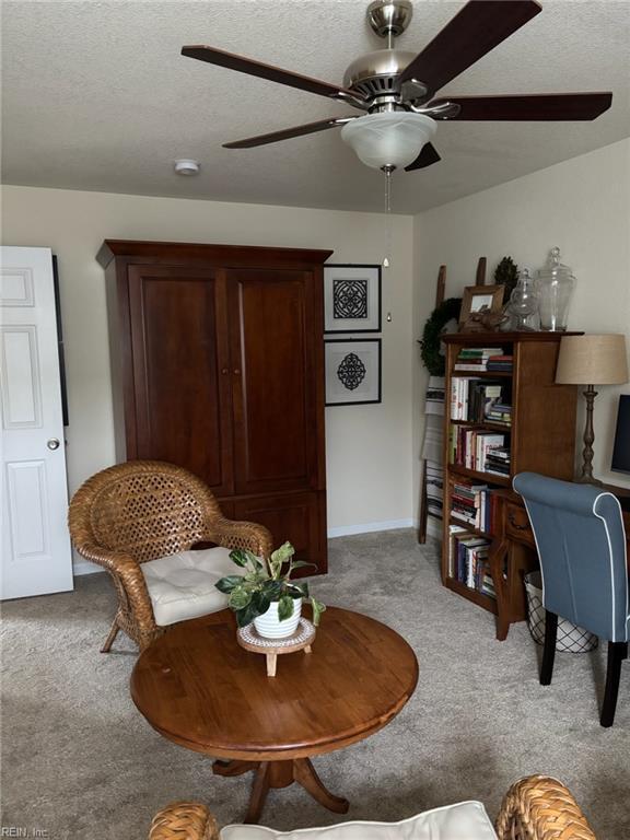 interior space with ceiling fan, light colored carpet, and a textured ceiling