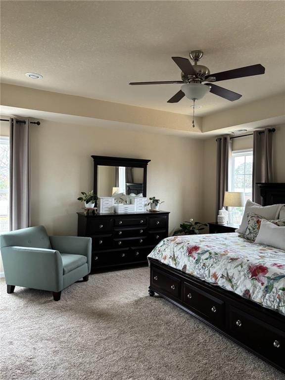 carpeted bedroom with ceiling fan and a textured ceiling