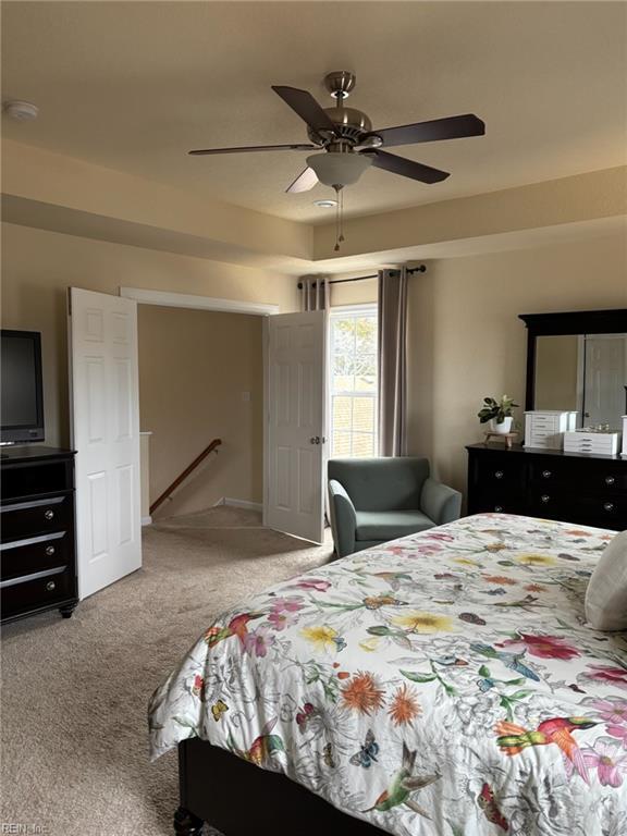 bedroom with ceiling fan and light carpet