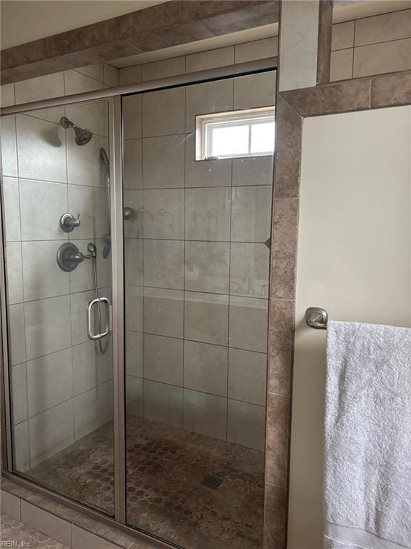 bathroom featuring a shower with door