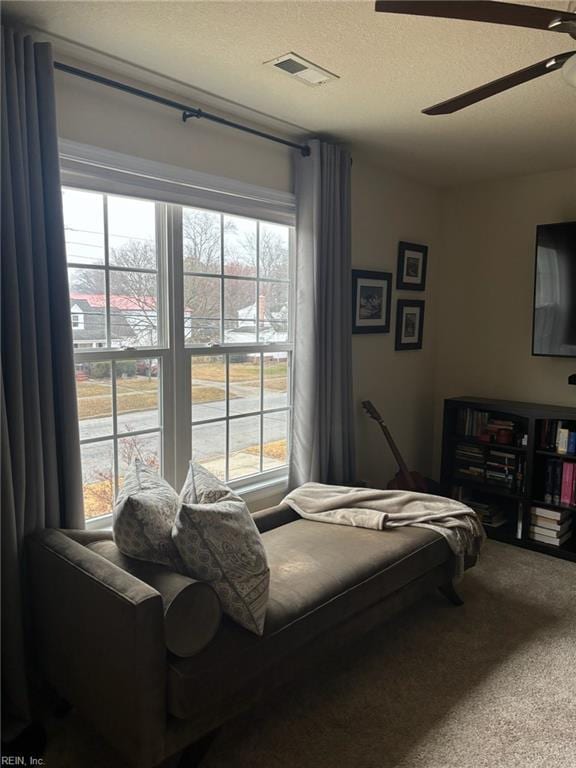 bedroom with ceiling fan, carpet floors, and a textured ceiling