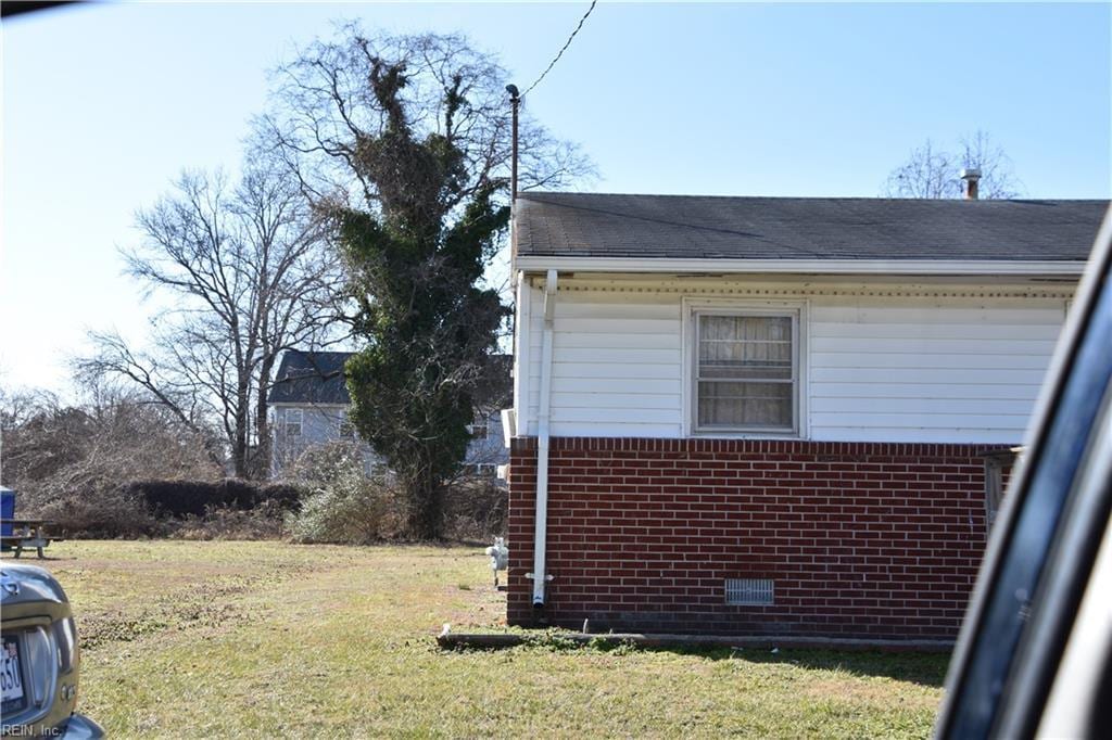 view of side of home with a yard