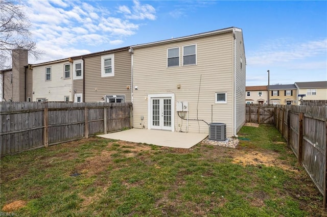 rear view of property with french doors, a yard, central AC, and a patio