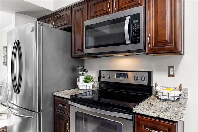 kitchen with dark brown cabinetry, appliances with stainless steel finishes, and light stone countertops