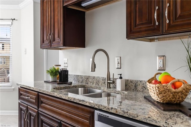 kitchen with sink, ornamental molding, stainless steel dishwasher, light stone counters, and dark brown cabinets