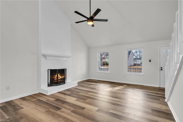 unfurnished living room featuring hardwood / wood-style floors, a fireplace, high vaulted ceiling, and ceiling fan