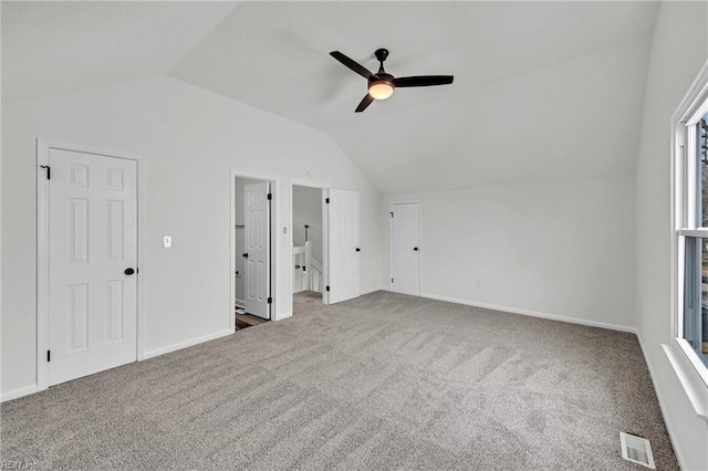 unfurnished bedroom featuring ceiling fan, lofted ceiling, carpet flooring, and connected bathroom