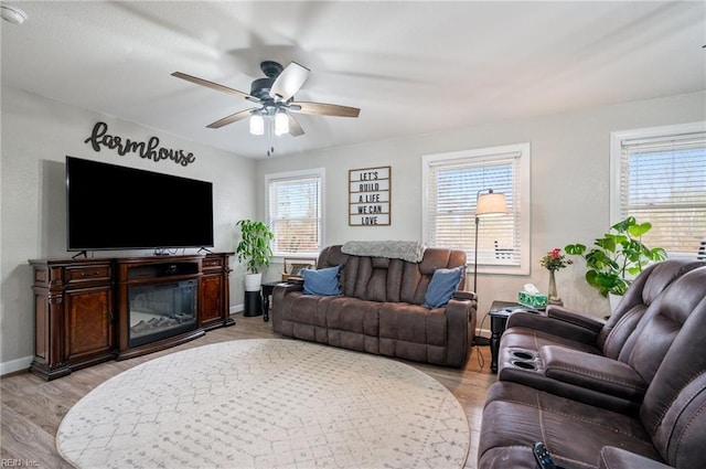 living room featuring ceiling fan, light hardwood / wood-style flooring, and a healthy amount of sunlight