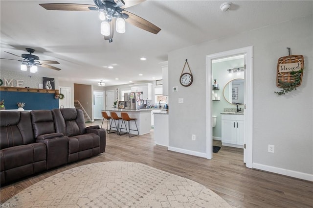 living room featuring ceiling fan and light wood-type flooring