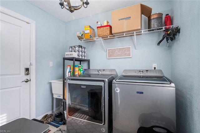 laundry room featuring an inviting chandelier and washer and dryer