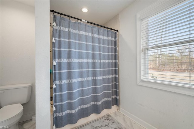 bathroom featuring toilet and walk in shower