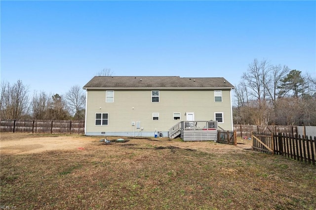 rear view of house featuring a wooden deck and a lawn