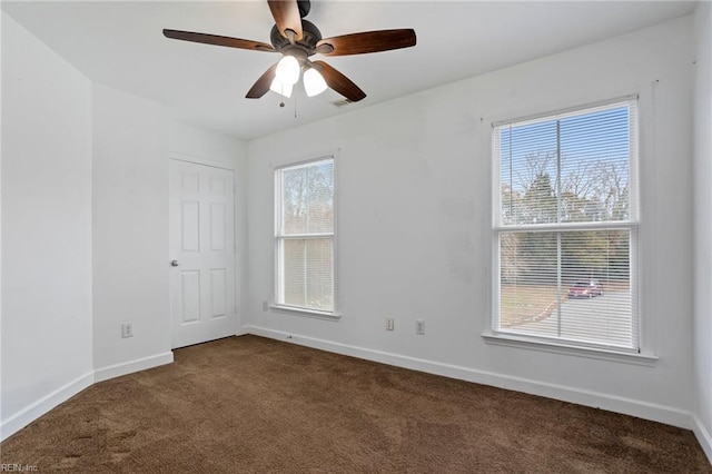 carpeted spare room featuring ceiling fan