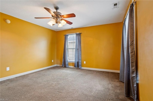 unfurnished room with ceiling fan and carpet