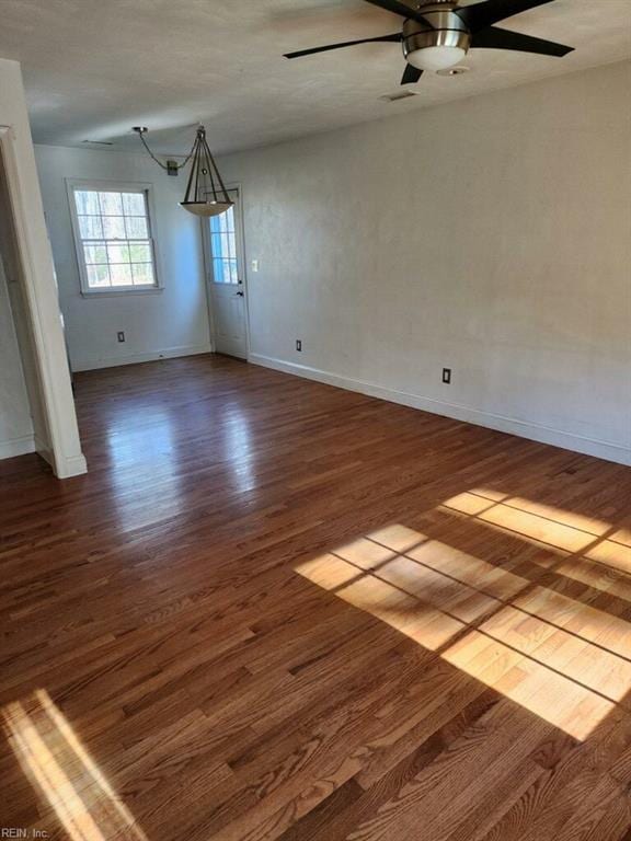 unfurnished room featuring dark wood-type flooring and ceiling fan